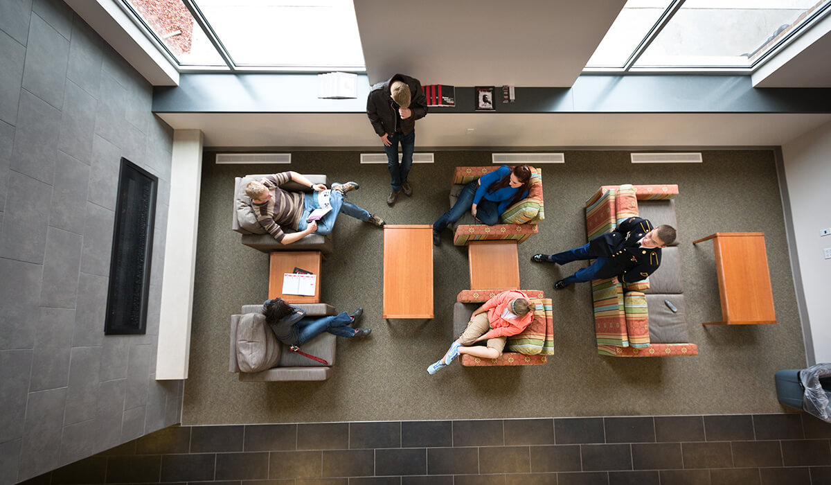 aerial view of study group on chairs in a lounge area near a fireplace