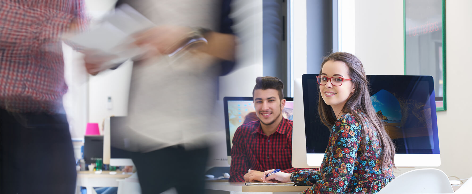 Young adults in a busy office or co-work space.