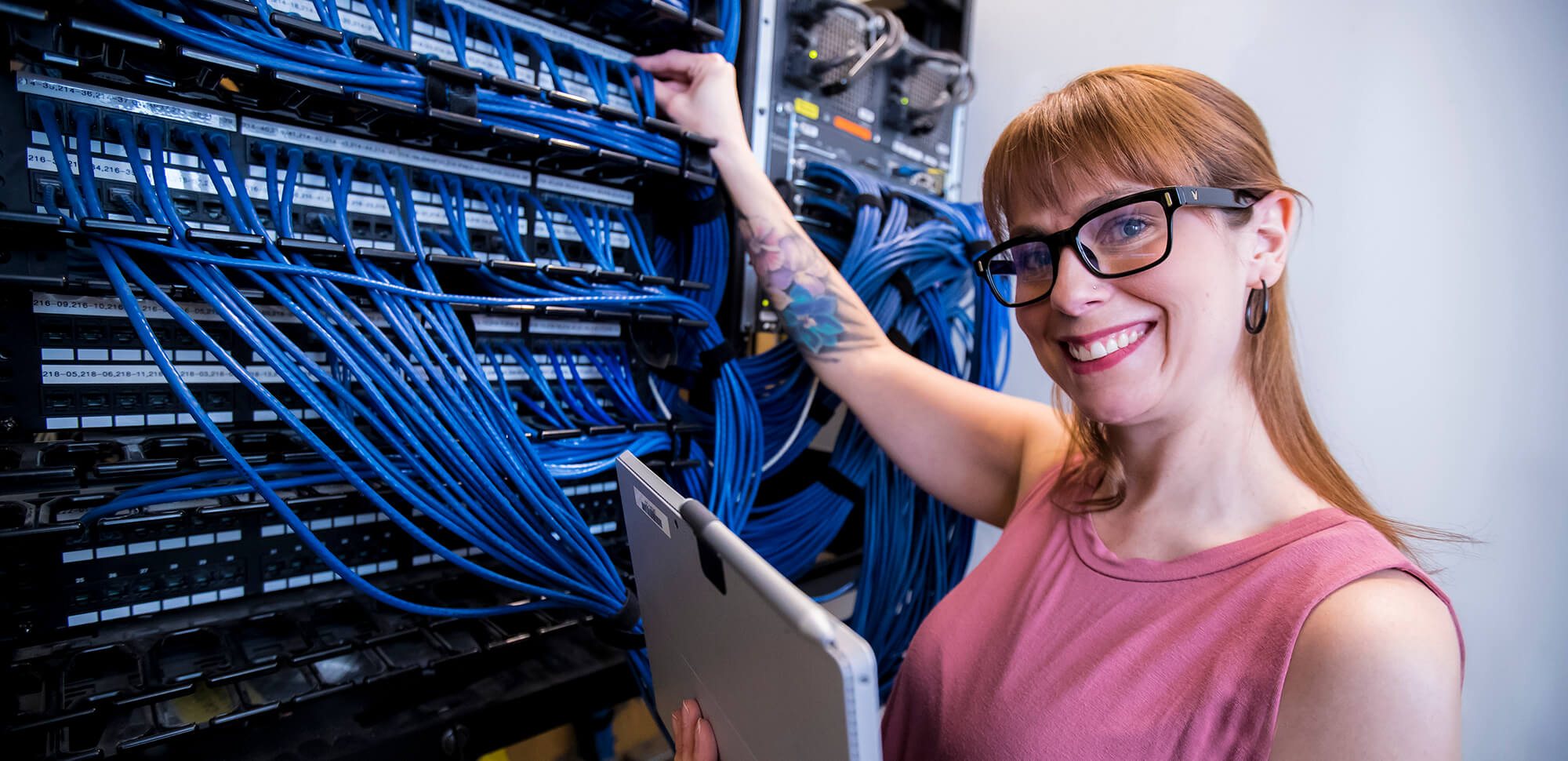 Casper College student standing in front of a bunch of servers.