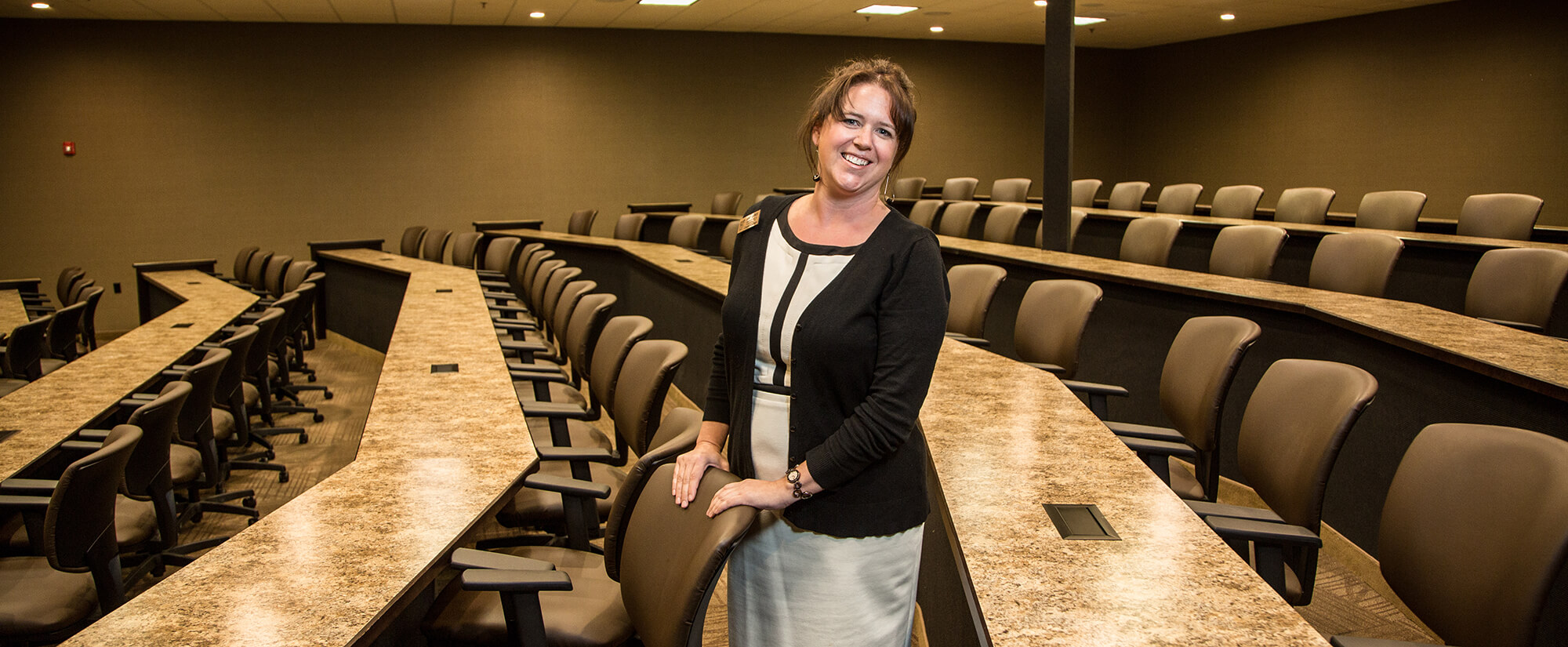 Marketing instructor smiling at the camera in an empty classroom.