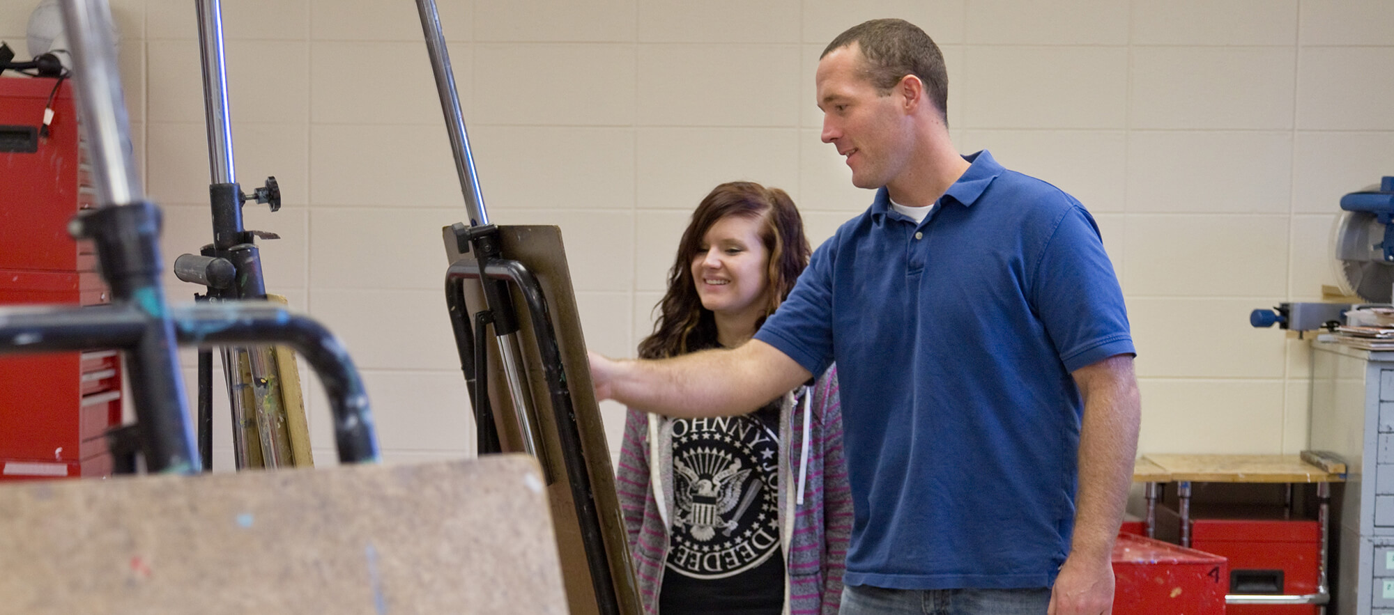 accounting-casper-college An art instructor provides guidance to a student standing at an easel in a classroom