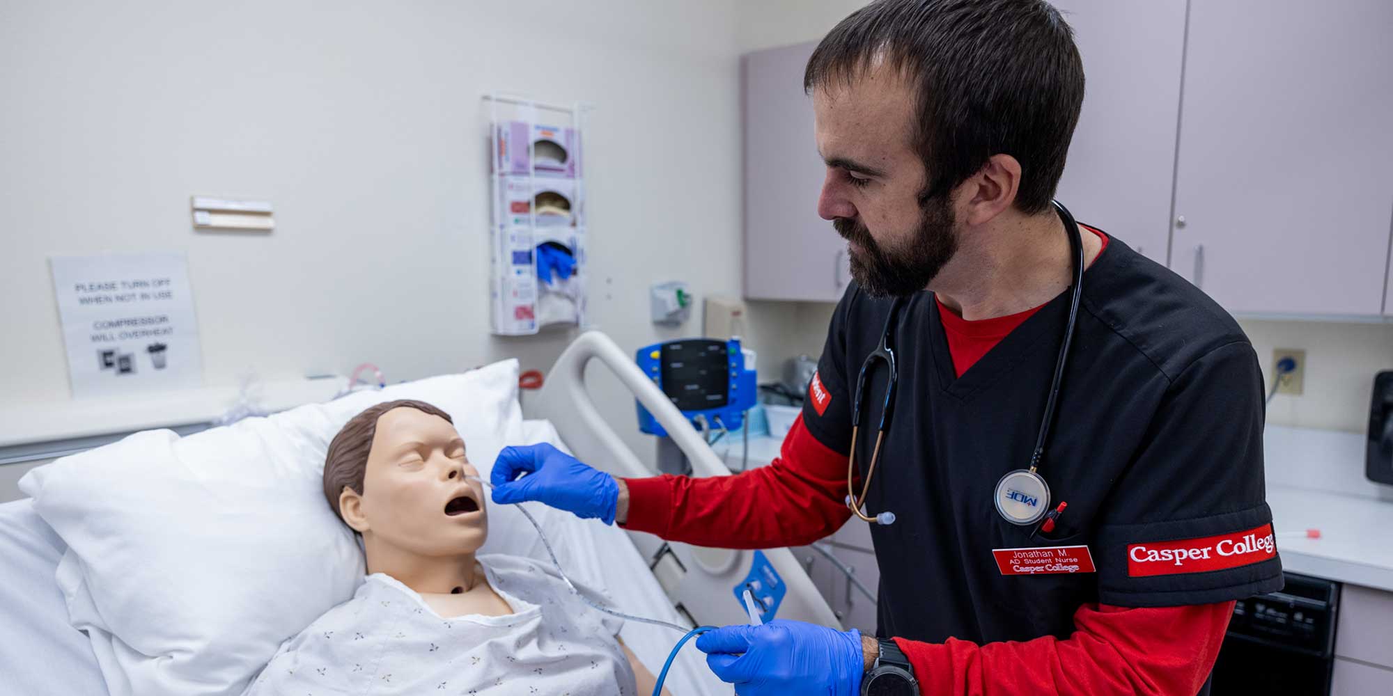 Nursing student working with training dummy