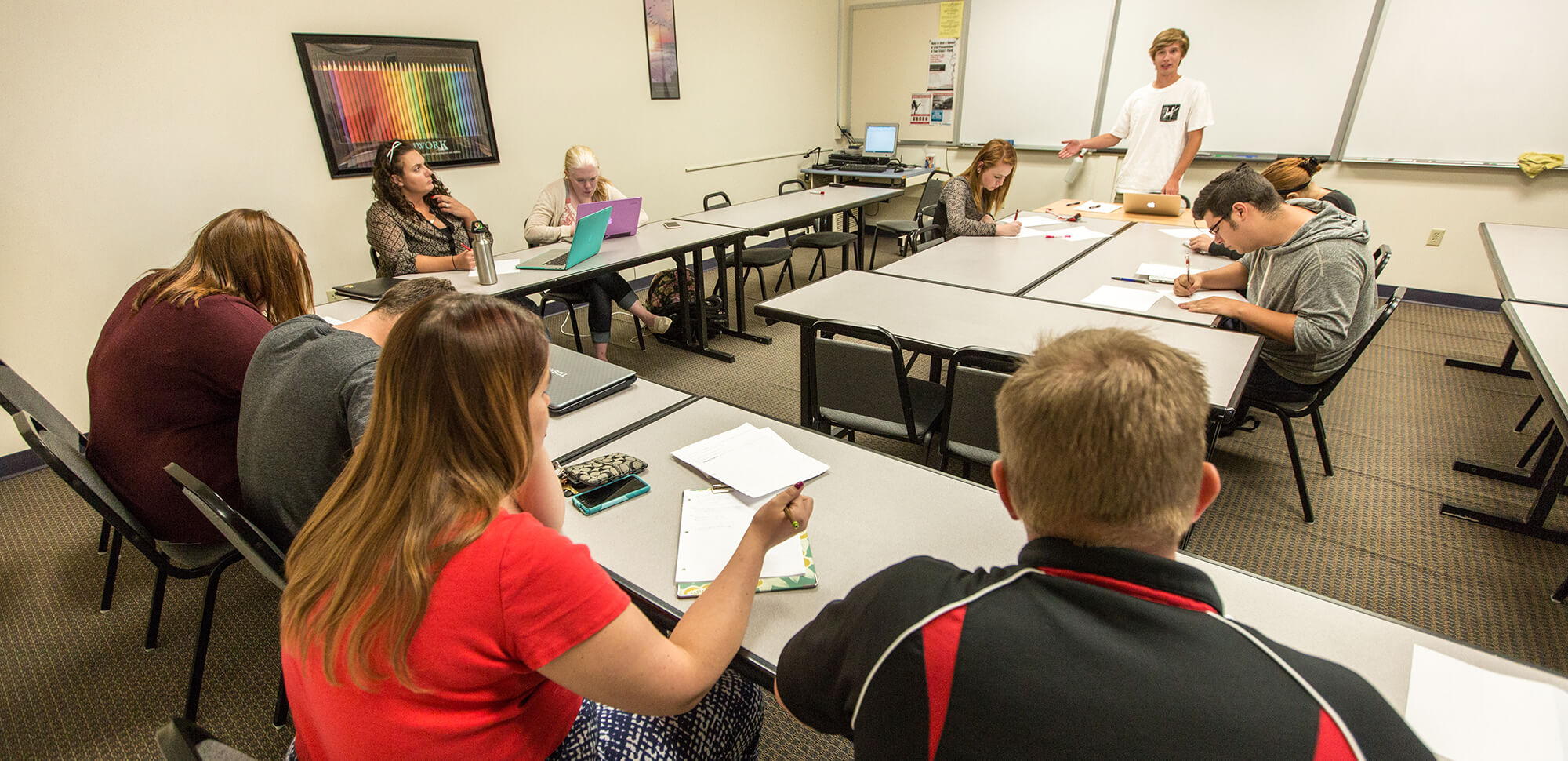 accounting-casper-college A student stands and speaks to a small group of his peers.