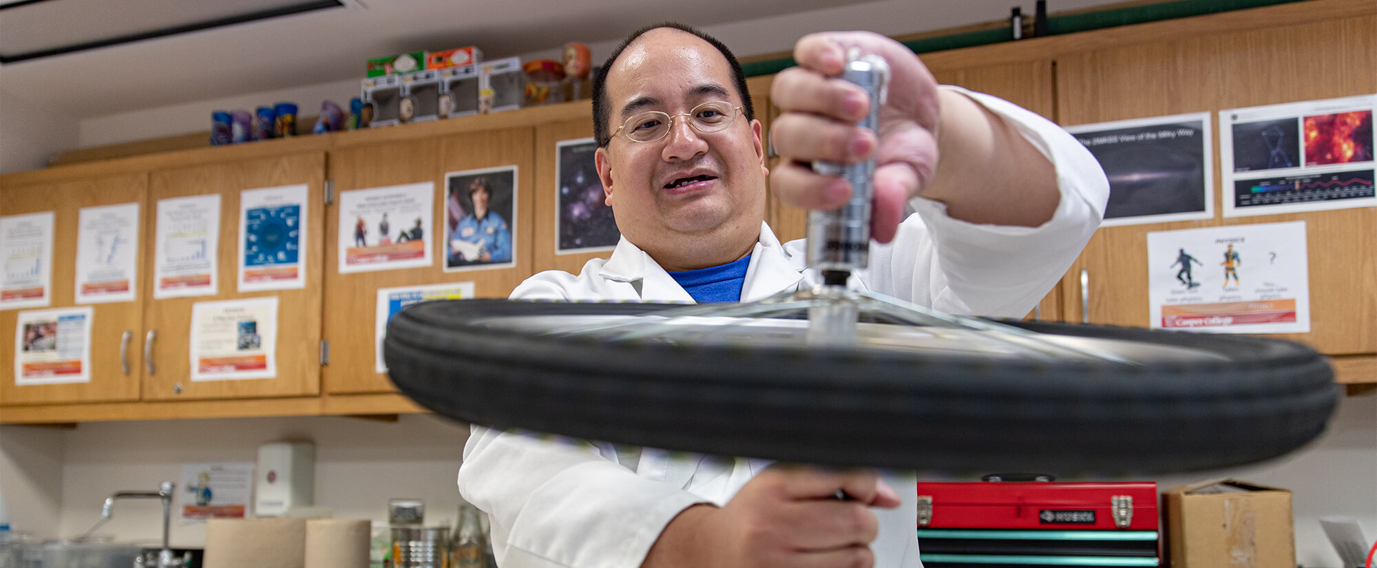 Instructor demonstrates physics related to a bicycle wheel.