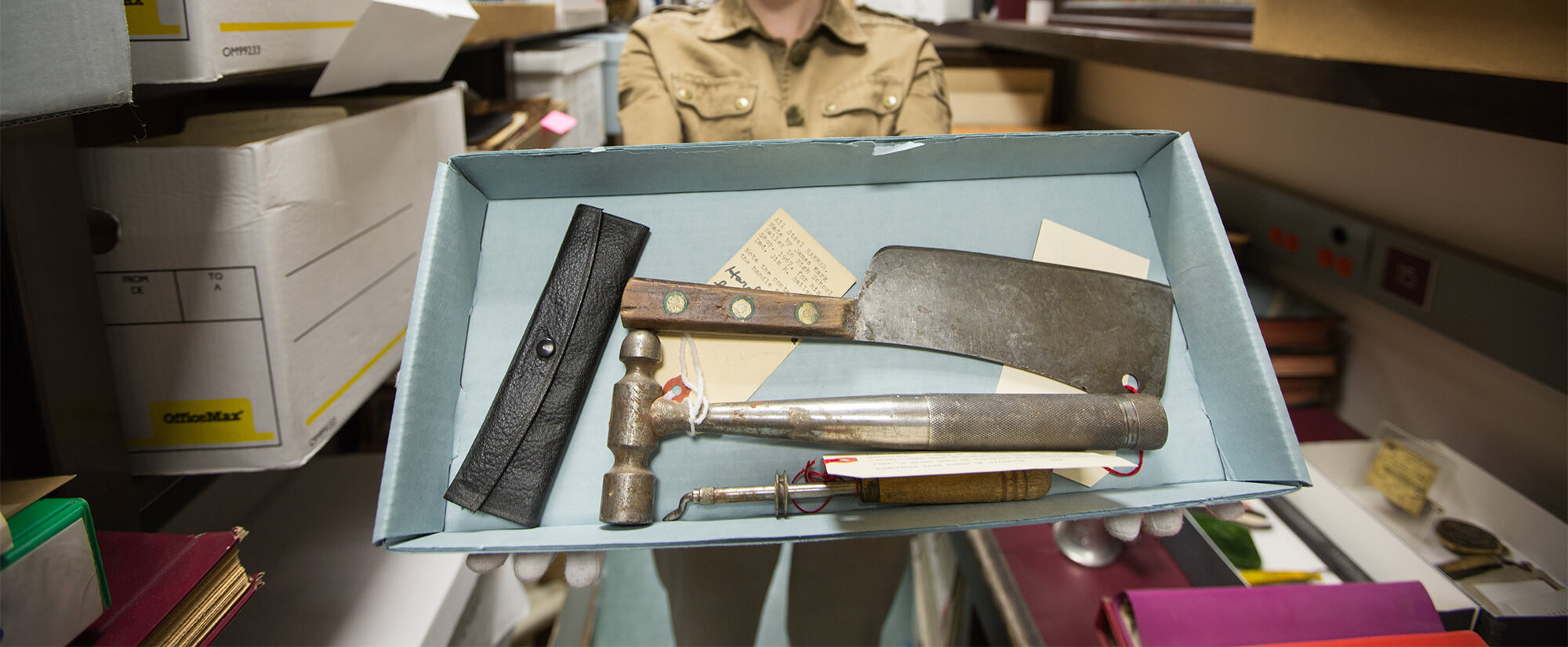 close up photo of someone in a museum holding a box of artifacts