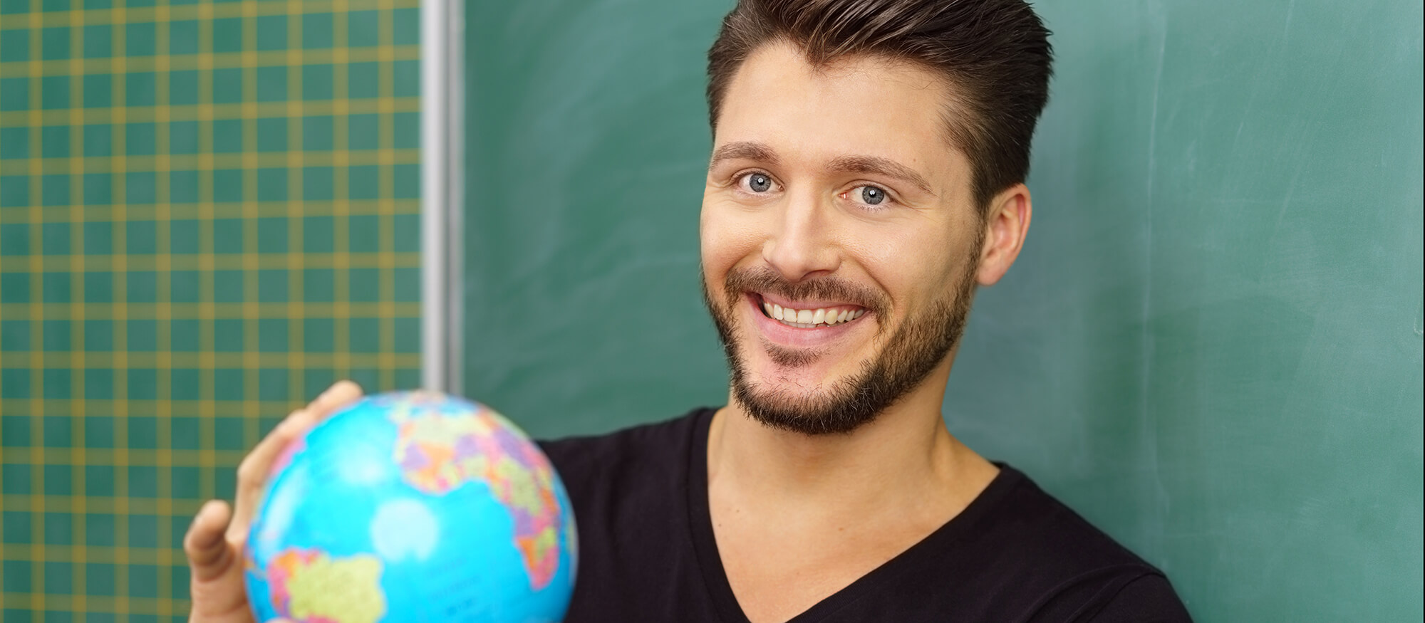 Photo of a man holding a globe.