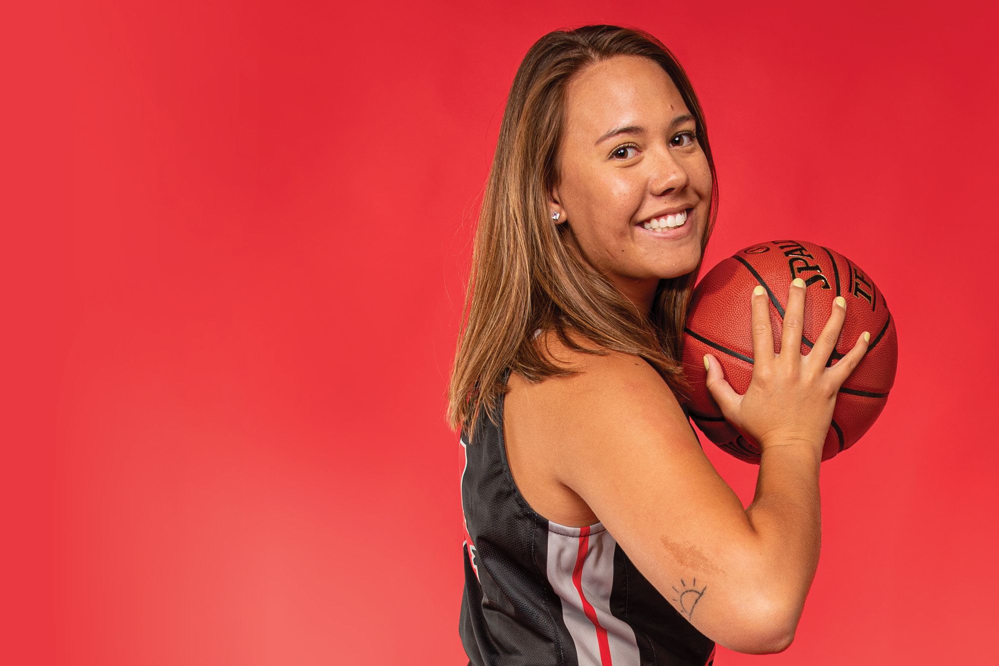 Casper College basketball player Ashley Tehau holding a basketball.