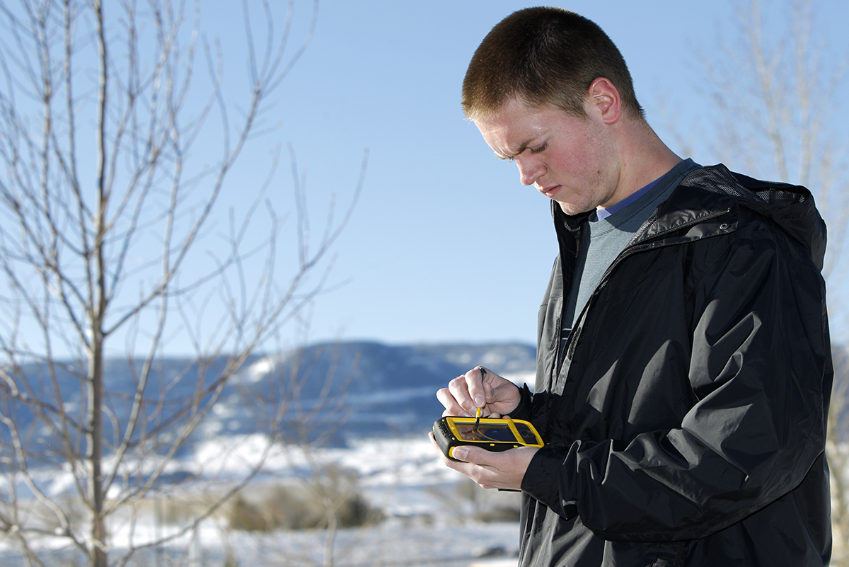 Photo of male student using a GIS device.