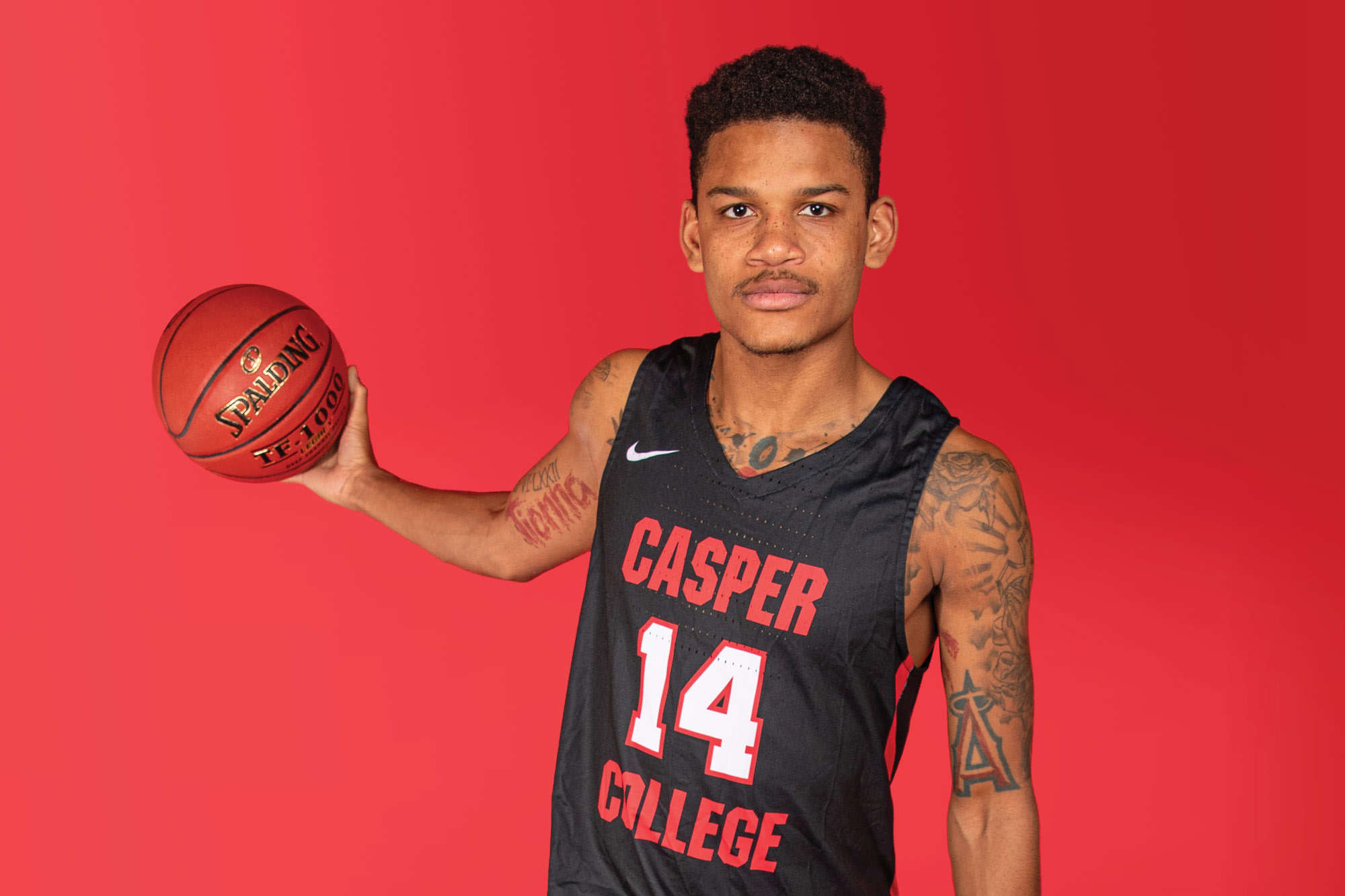 Casper College basketball player Tavion Robinson holding a basketball.