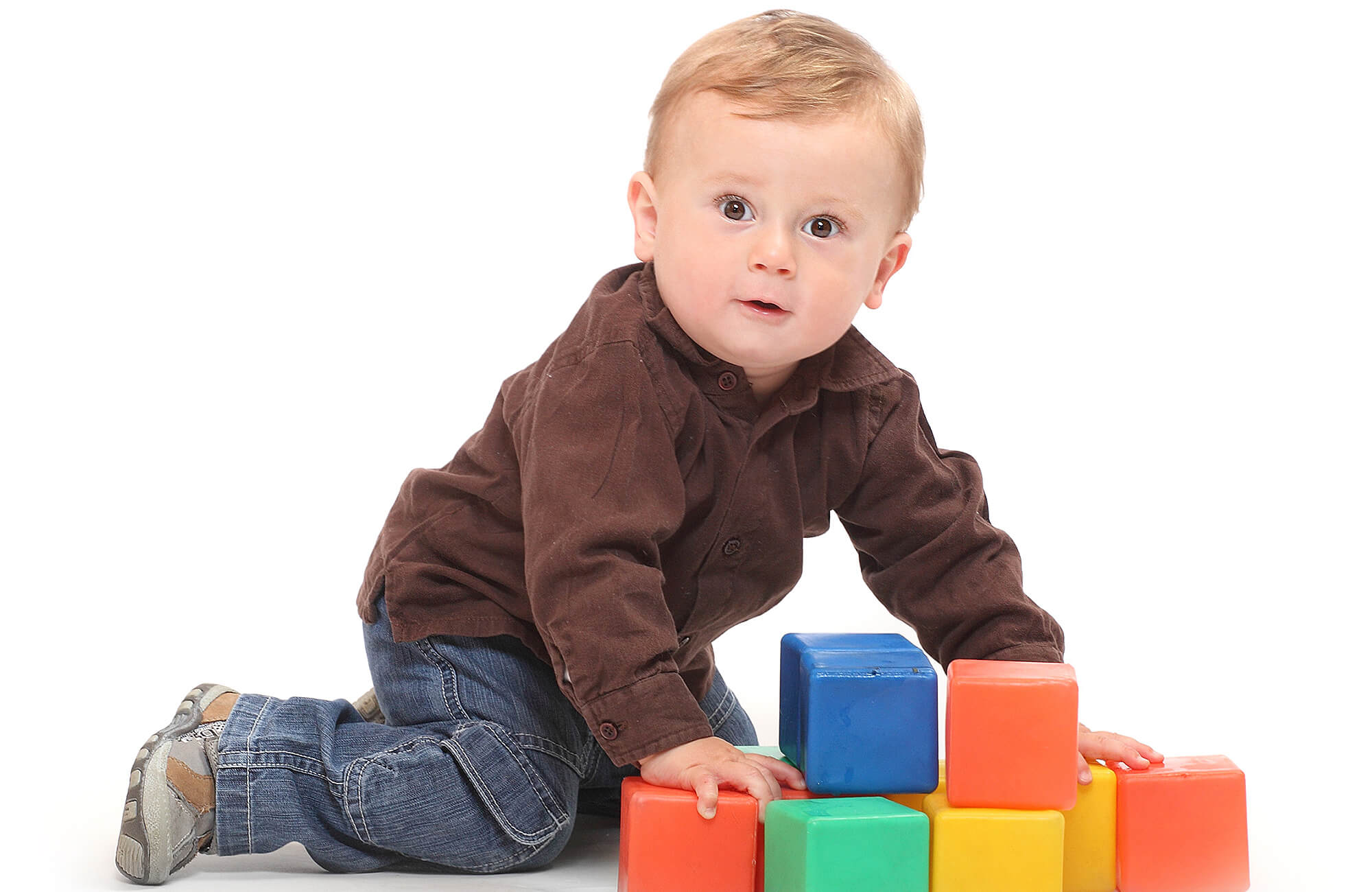 Photograph of toddler with plastic blocks.