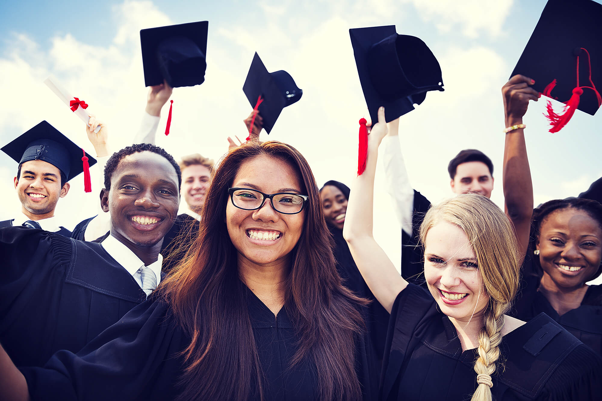 Photo of graduates throwing their caps in the air.