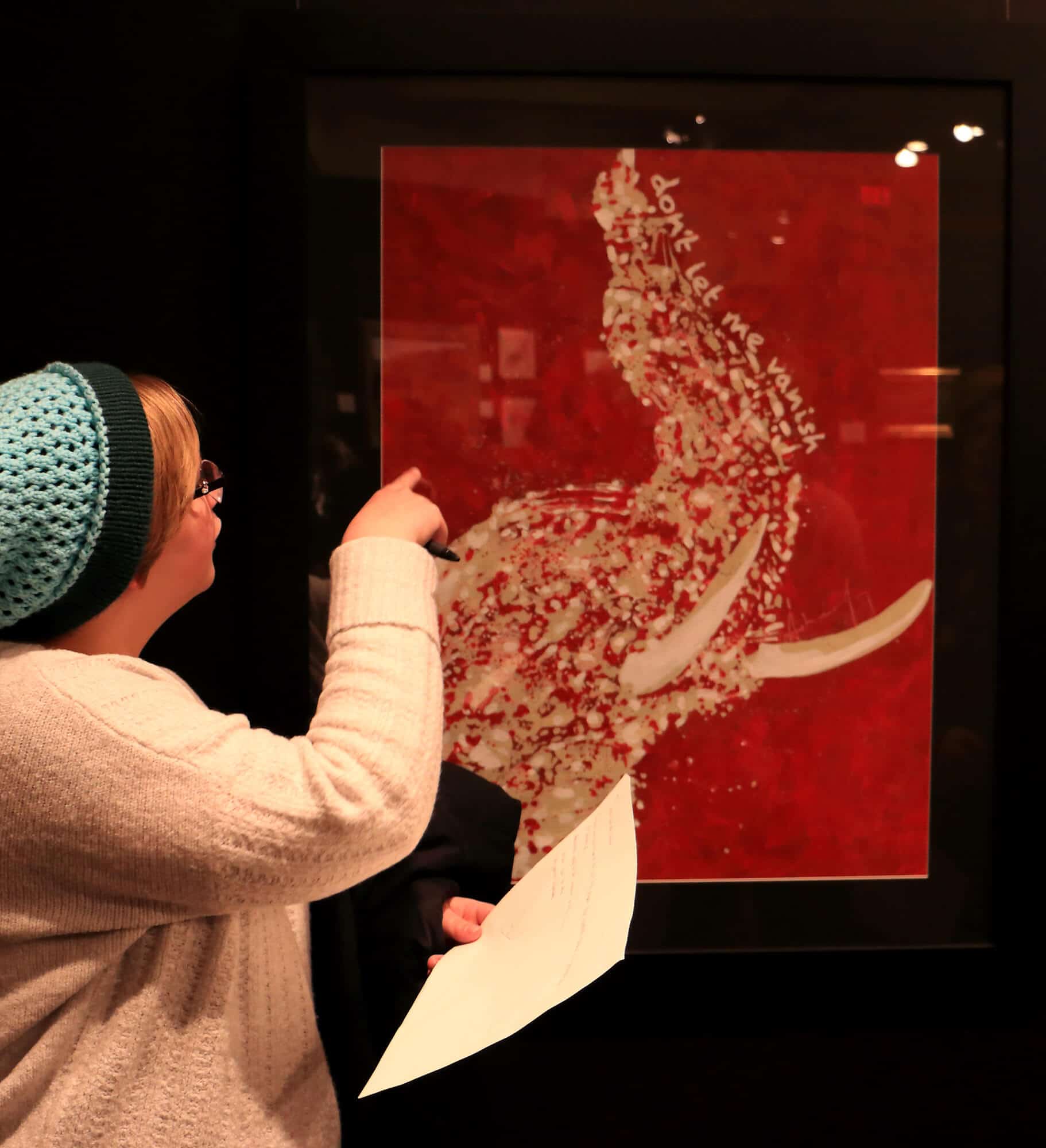 Student pointing at a artistic rendering of an elephant head