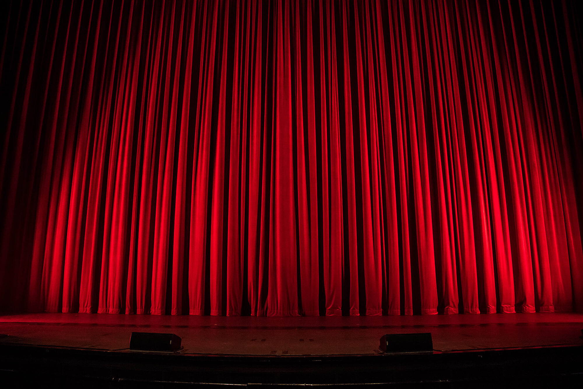 Photo of closed red curtains.