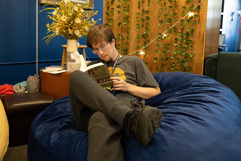 man sitting on a bean bag and reading a book