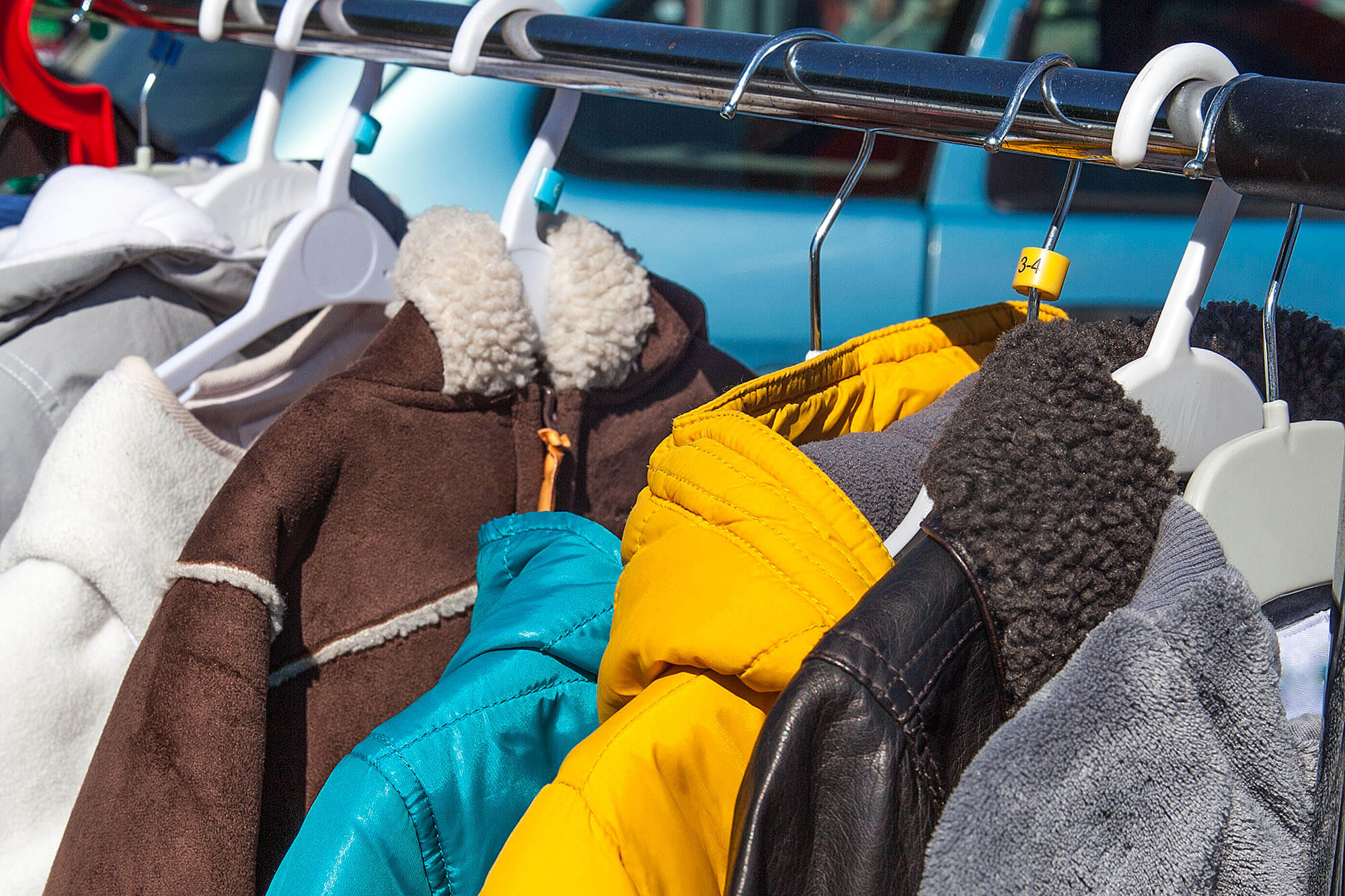 Photo of winter coats hanging on a rack to illustrate the radiography students' coat drive press release.