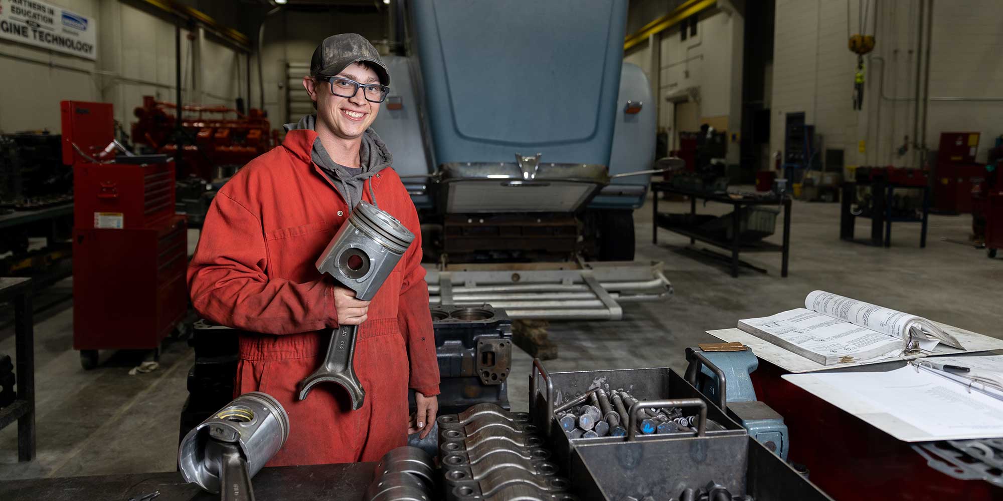 diesel technology student in front of truck with tools