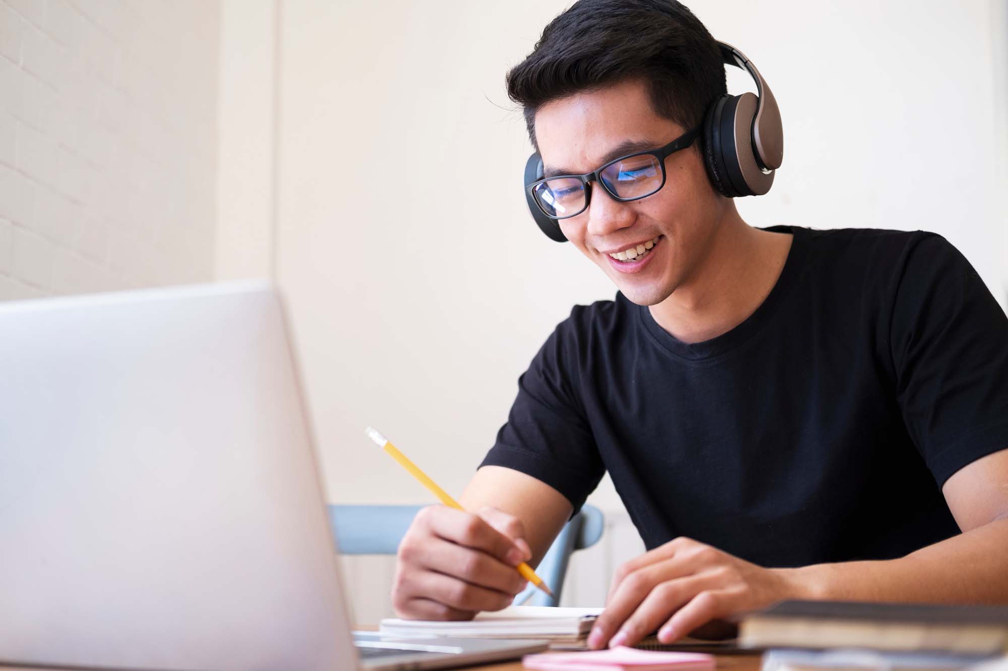 Young man student study at home. He using laptop and learning online.