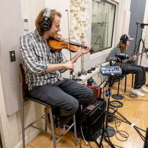 Photo of two musicians practicing in a recording studio at Casper College.