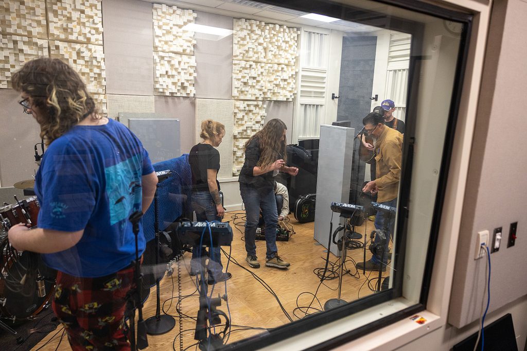 Photo of Casper College students setting up equipment in a recording studio.