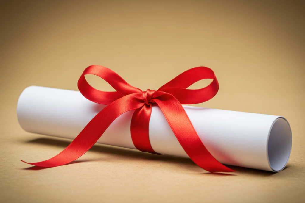 A rolled diploma tied with a red silk ribbon, representing the Fall 2025 President's Honor Roll at Casper College.