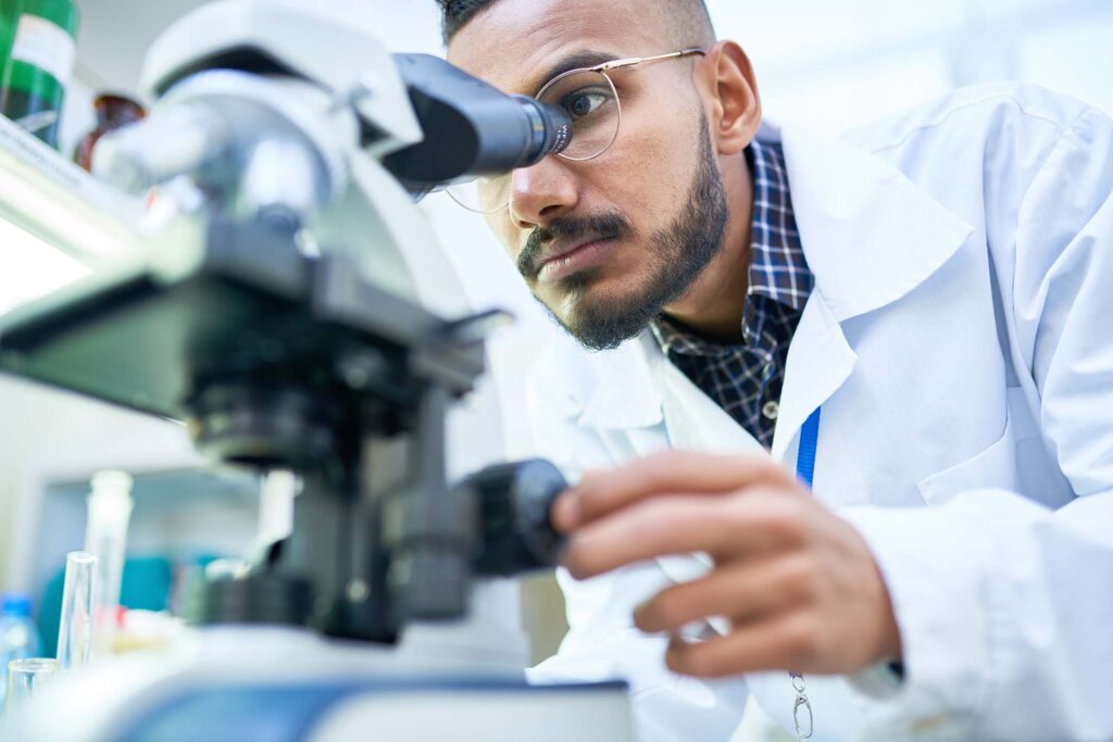 Student or researcher adjusting a microscope in a laboratory. health science