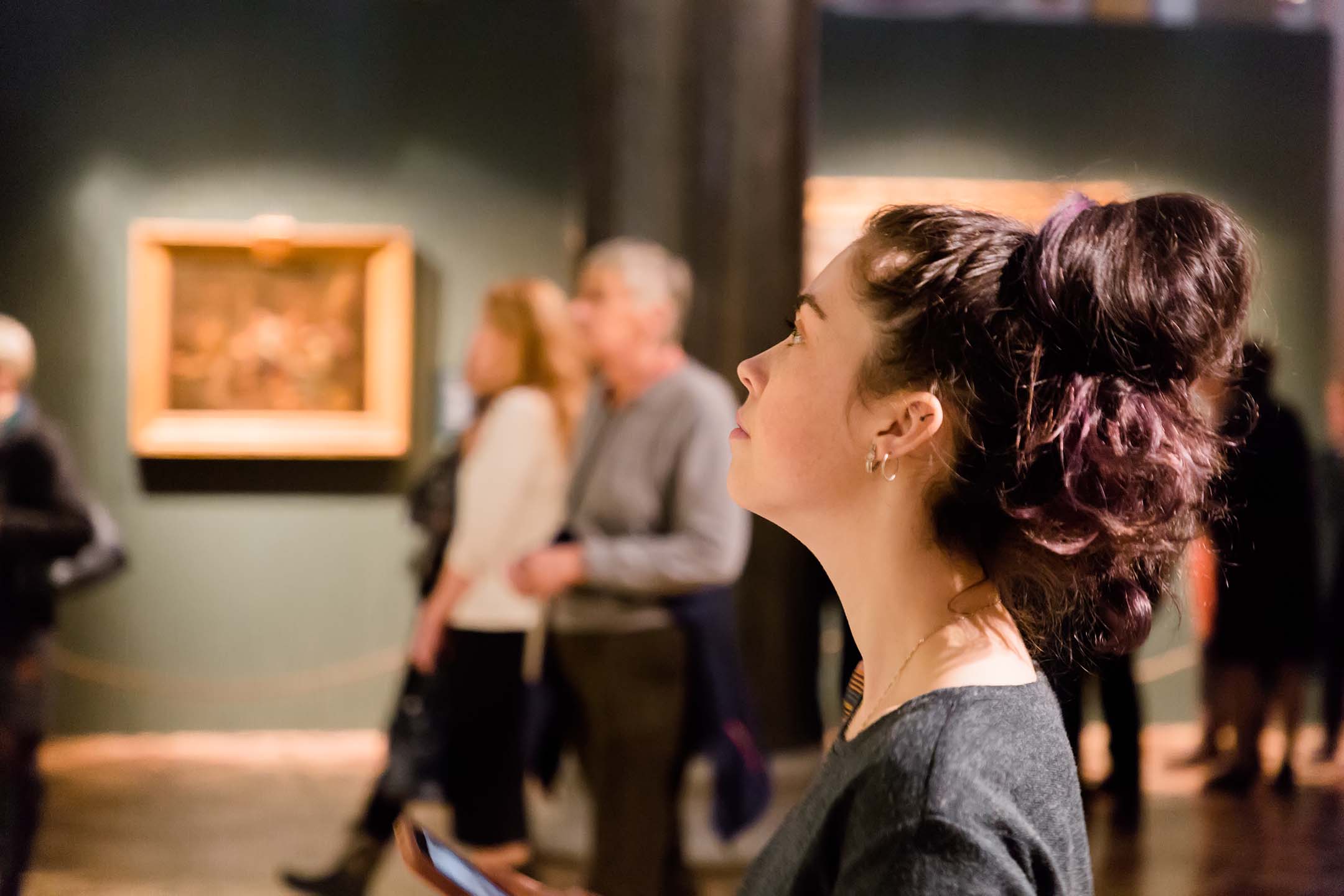 Woman looking at artwork in a museum gallery.