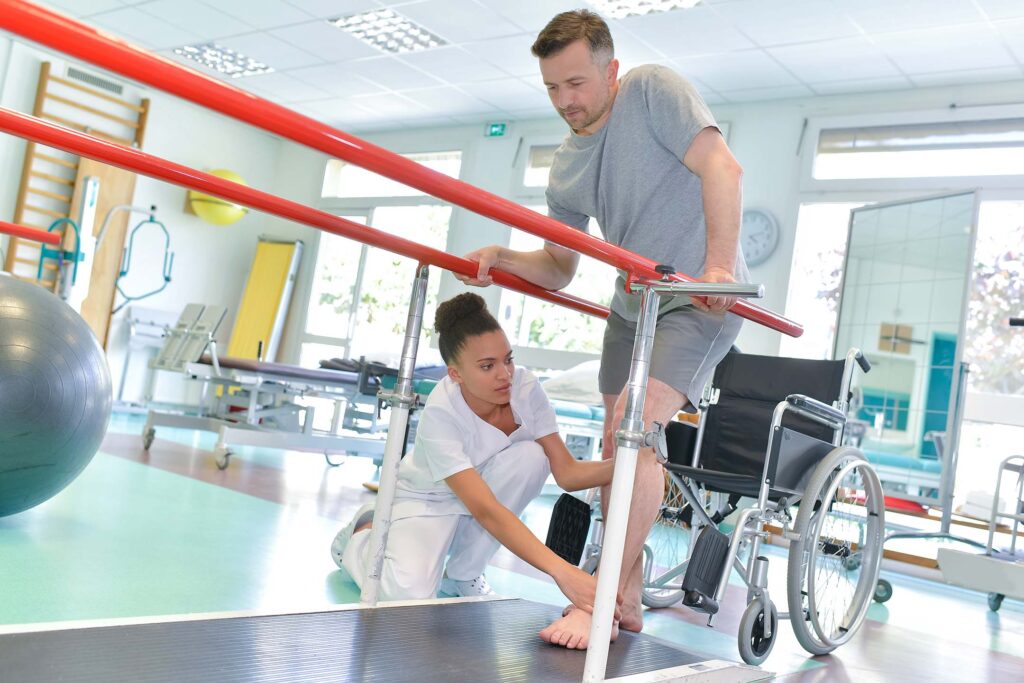 Therapist assisting a patient with movement exercises in a rehab setting. Occupational therapy assistant