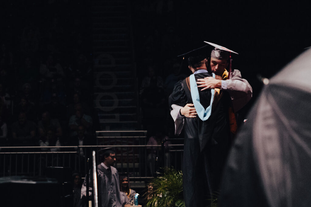 An instructor hugging a student at Casper College graduation