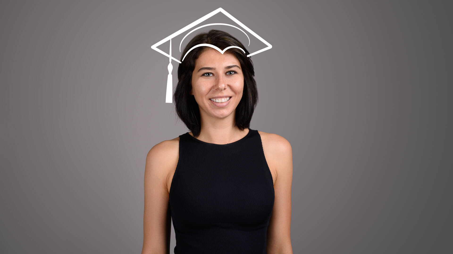 A young woman with black hair smiles against a gray studio background with a graduation cap drawn in chalk above her head.