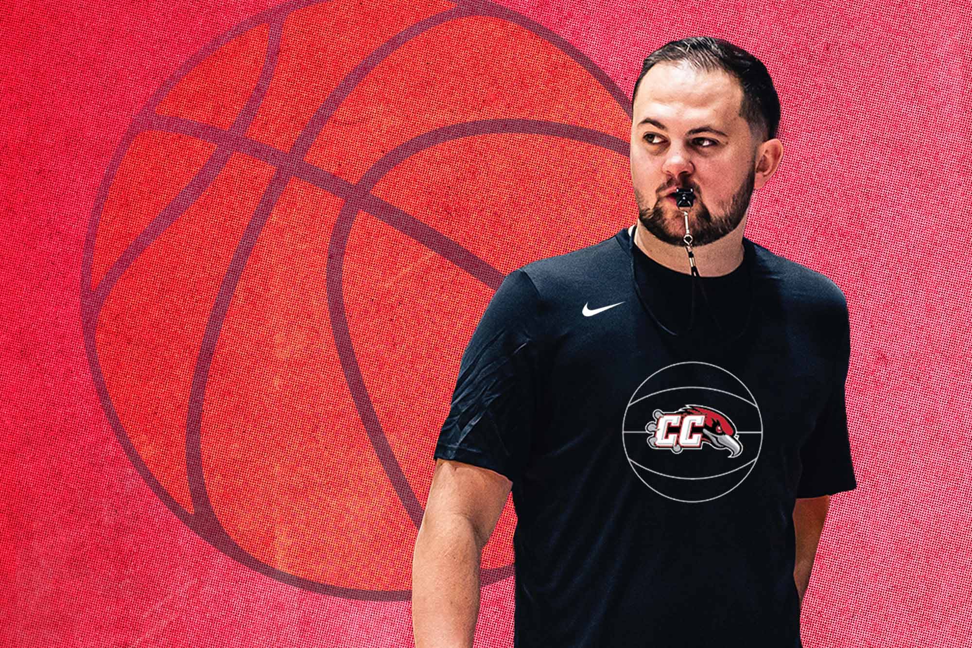 Casper College Men’s Basketball Head Coach Ty Larson wearing a black CC whistle-logo shirt against a red basketball background.