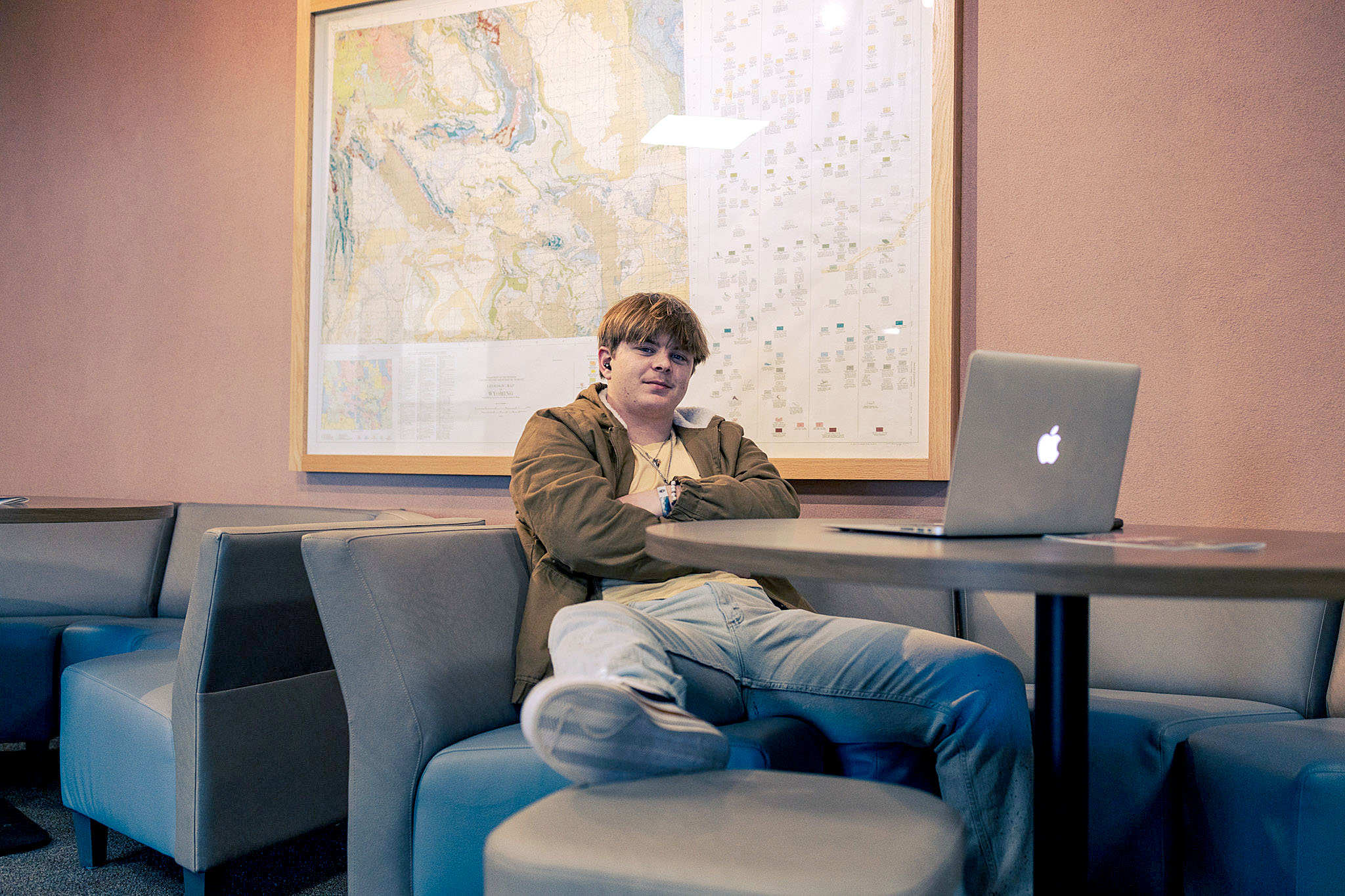 student-marketing-photo Casper College student studying with a laptop under a large geological wall map in the Wold Physical Science Center.