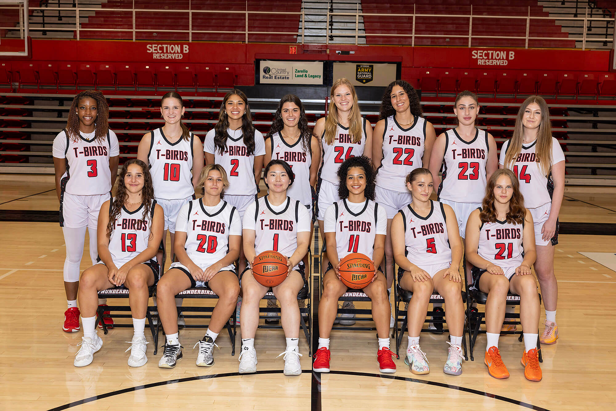 2025-2026 Casper College Lady T-Birds women's basketball team posing for a group photo in their white uniforms on the court.