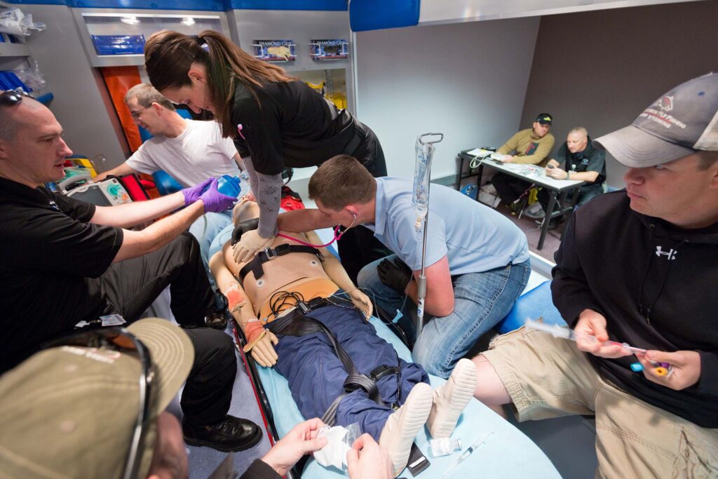 Students perform a team-based emergency response simulation inside a fully equipped ambulance.