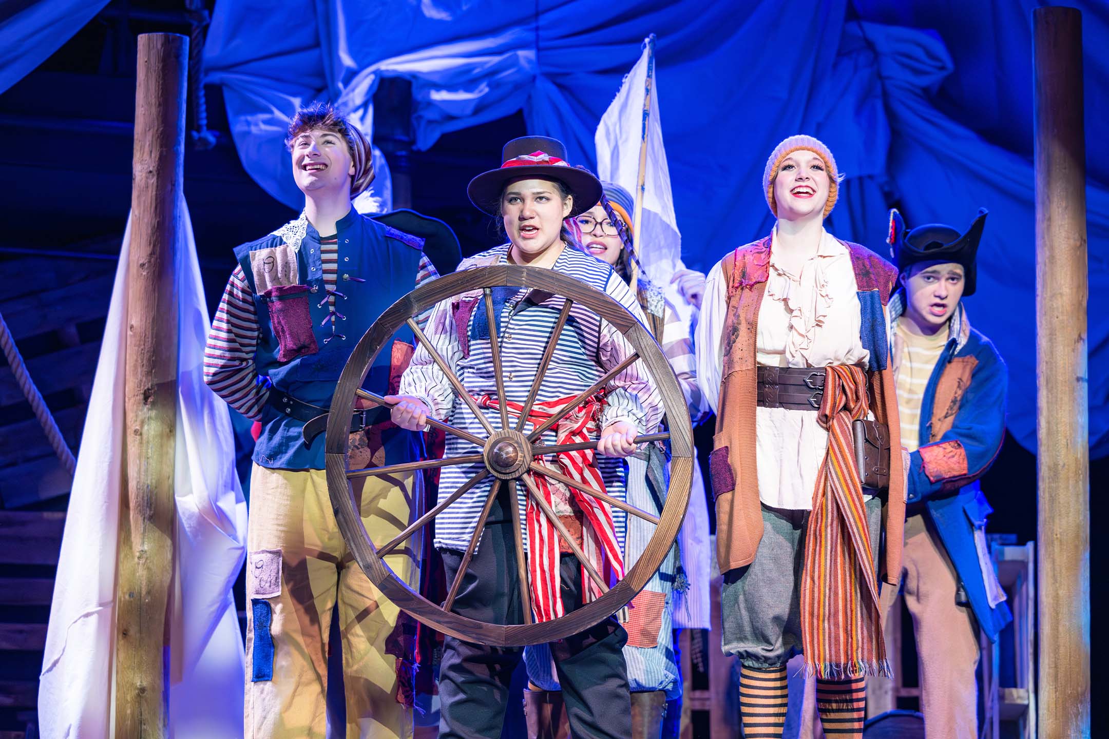 Musical theatre students perform aboard a pirate ship set during a stage production.
