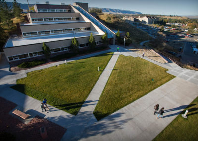 Eagle's eye view of students walking in front of a 4-level building with geometric angles.