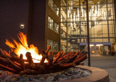 Flames from the fire ring in front of the Student Union-UW/CC building flicker in the evening breeze.