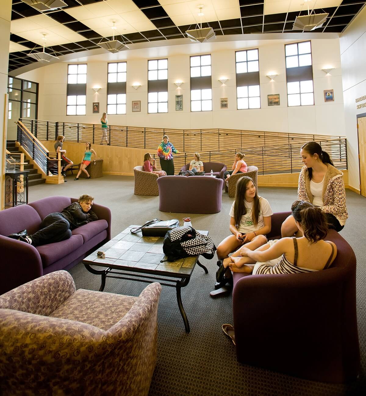 Photo of students in different study areas in a large sun-lit common space in the Krampert Complex