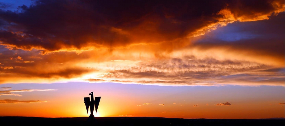 iconic Casper College metal bird silhouetted against the sunset