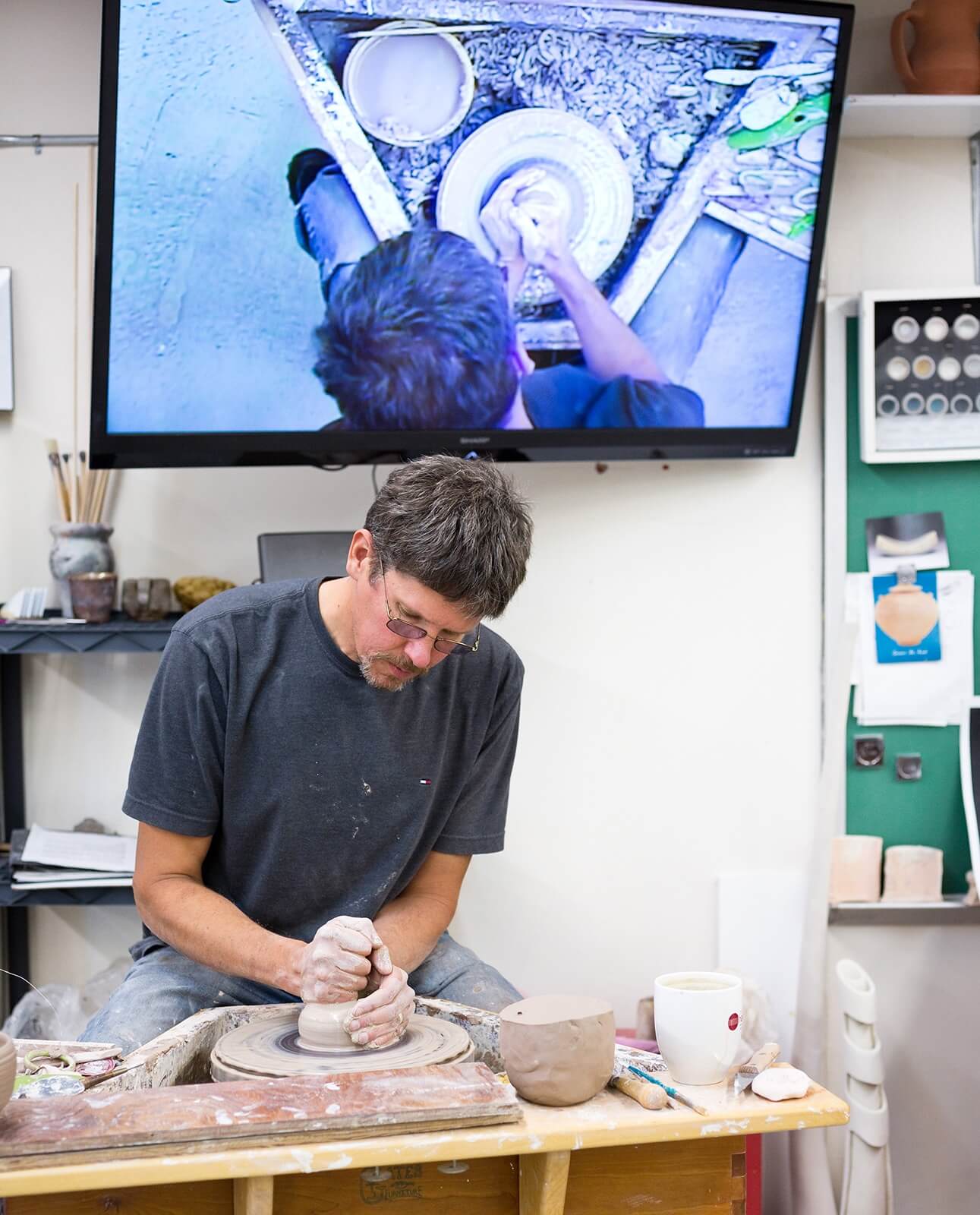 Photo of pottery instructor making a pot on a wheel